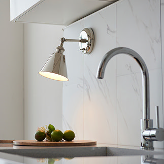 image of nickel wall light with conical shade attached to a marble wall over a kitchen sink