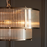close up image of ribbed glass tiered pendant light, emitting warm glow from within