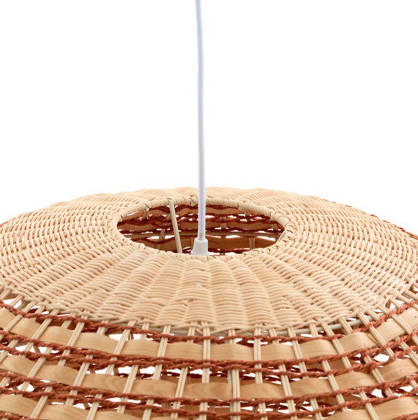 close up image on top of woven rattan light shade showing where white fixture cable goes into circle on top of shade