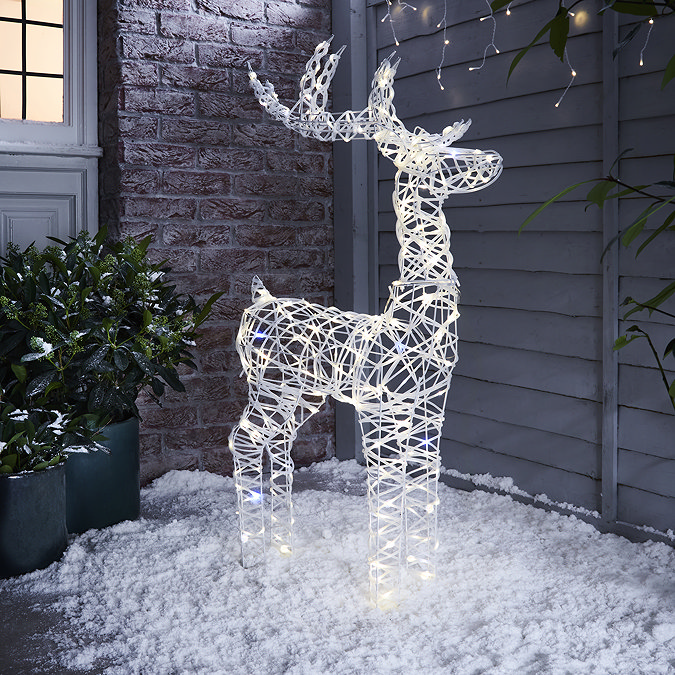 white rattan light up reindeer in snow at the front of the house.