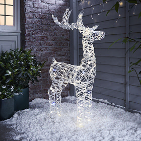 white rattan light up reindeer in snow at the front of the house.