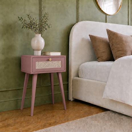 image of clay pink 1 drawer nightstand with rattan front, next to bed with clay pink pillows