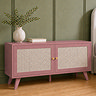 image of clay pink rattan fronted small tv unit in front of green wall