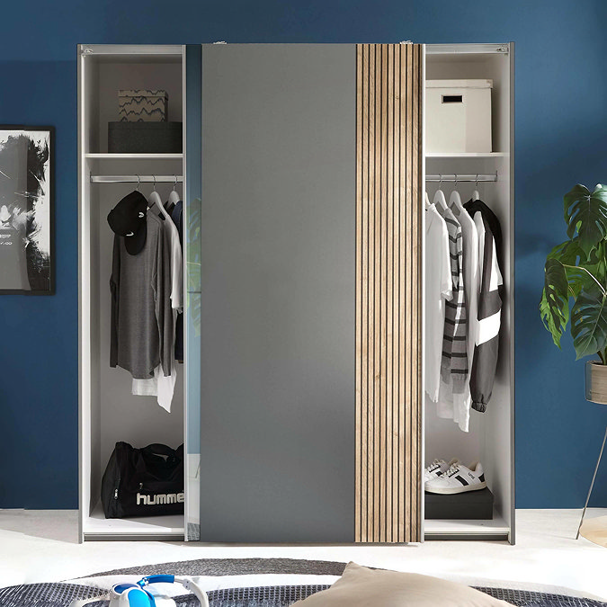 image of wide grey wardrobe with sliding doors overlapping in the middle to reveal clothes stored within