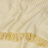 close up image of yellow patterned throw with tasseled edges