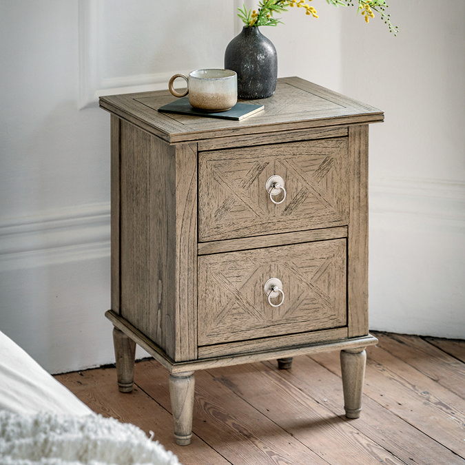 image of rustic, lightly patterned ashy wood bedside table with two drawers, on wooden flooring topped with mug and vase
