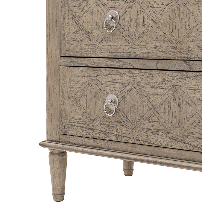 close up image cut out on white background of carved feet and bottom drawer of ashy wooden chest