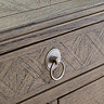 close up image of small hoop ring handles of ashy wood 7 drawer chest