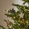 star hanging decorations on branches of a lit christmas tree