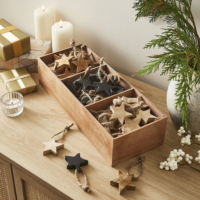 image of wooden box of star decorations, separated into three sections for cream, black, and brown colours.