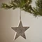wooden patterned star hanging from a christmas tree