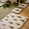 close up on cream and green placemats with festive woodland trees on them
