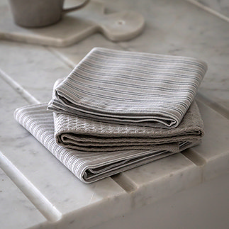 image of three grey stripe napkins folded and piled on marble kitchen counter