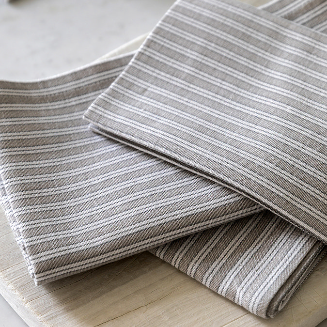 close up image of soft grey stripe napkins, highlighting pattern and colour
