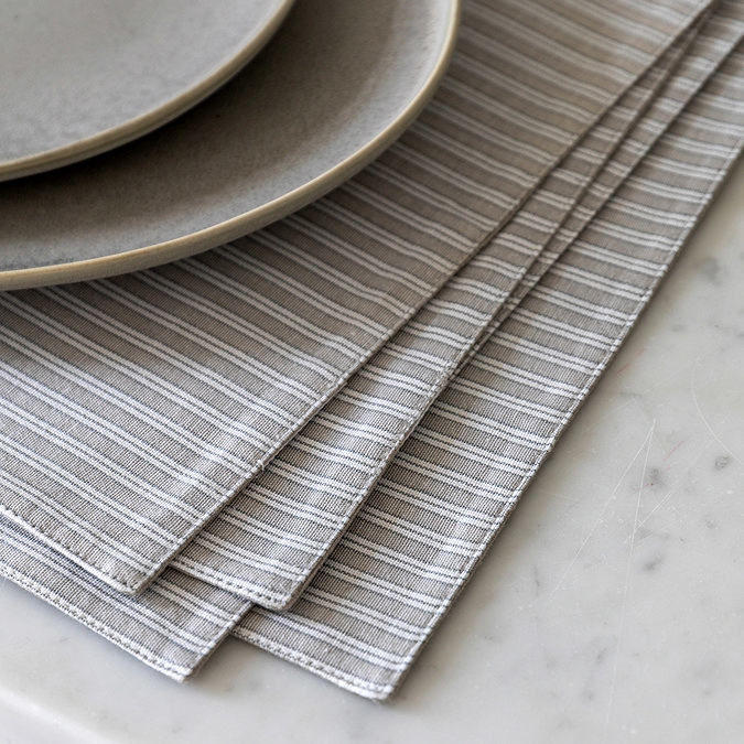 close up image of light grey striped placemats, highlighting pattern