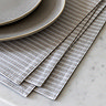 close up image of light grey striped placemats, highlighting pattern