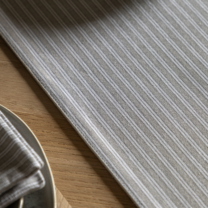close up on grey stripe pattern of table runner on light oak table