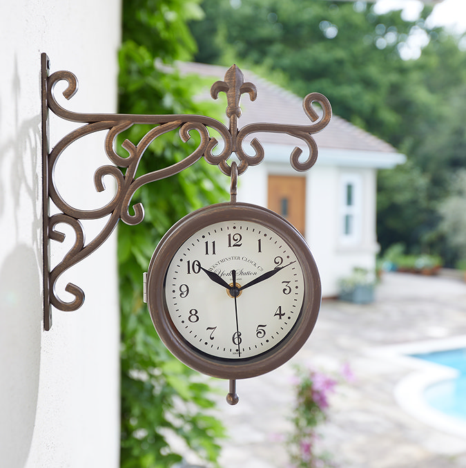 image of wall clock on white villa wall with pool in background