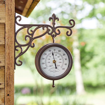 image of wall clock on white villa wall with pool in background