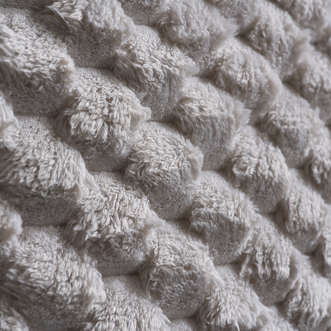 close up image of off-white faux fur texture of headboard