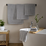image of set of silver-grey ribbed towels hanging around a bathroom